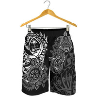 Black men’s swim shorts on wooden hanger, white turtle and Guam crest graphic