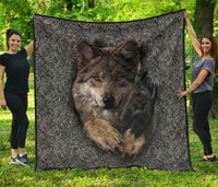 Black and gray quilt with wolf portrait centered and swirling pattern border, quilted texture