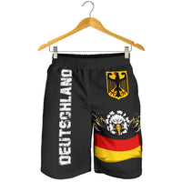 Schwarze Shorts an Bügeln, Adlerwappen und Schriftzug links