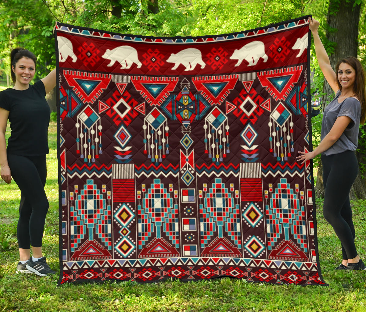 Native American-style quilt with white bear motifs and red geometric pattern border