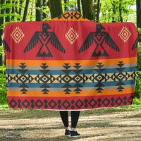 Red tribal patterned hooded blanket with zigzag and diamond motifs across center