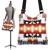 White boho tribal handbag with red, black, and gold geometric print and fringe hem