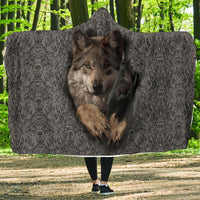 Gray hooded blanket with wolf face and swirl pattern, worn outdoors