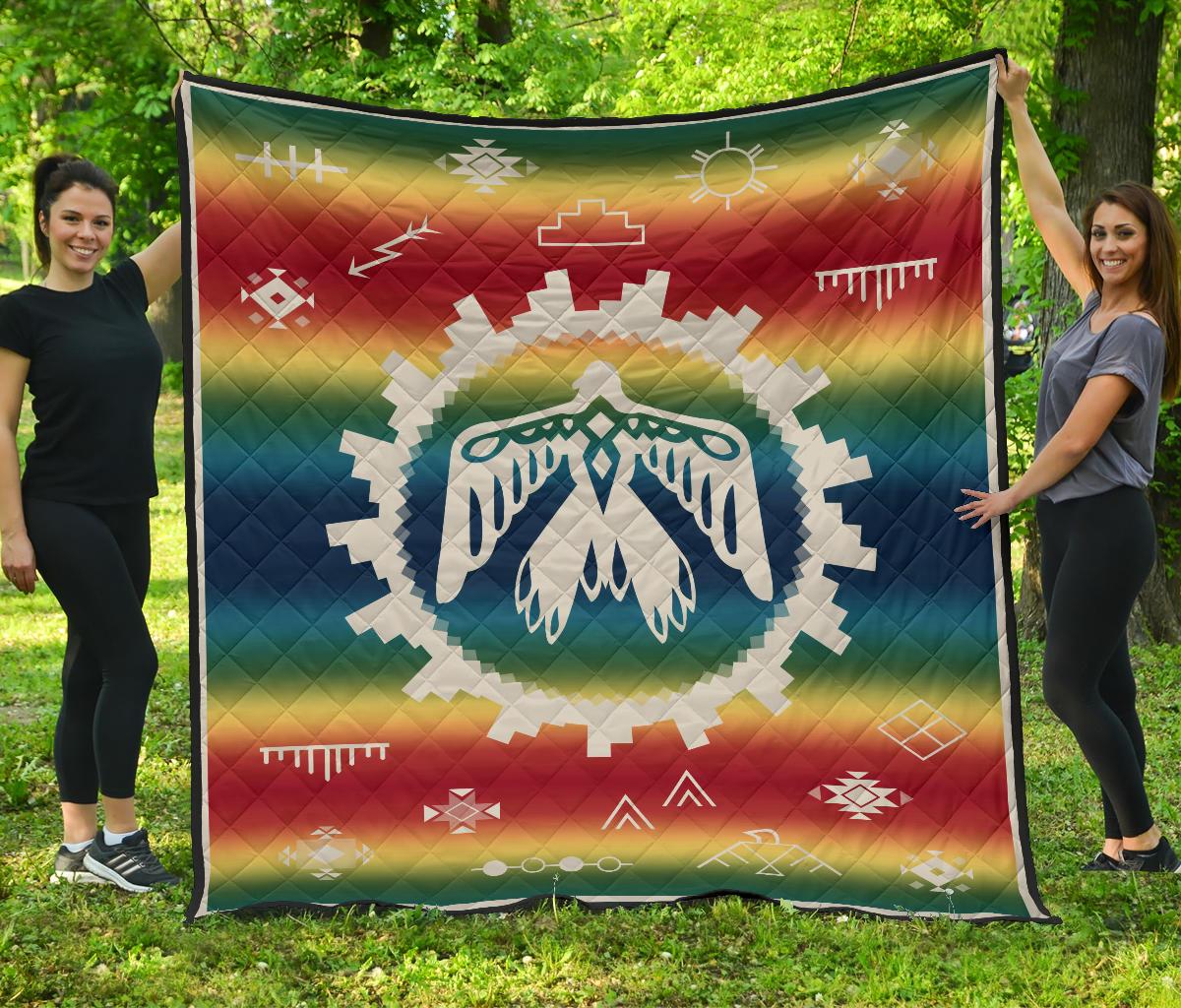 Rainbow quilt with white thunderbird emblem and geometric accents in colorful gradient