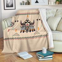 Beige blanket draped over sofa, Native bison print with multicolor triangles and border