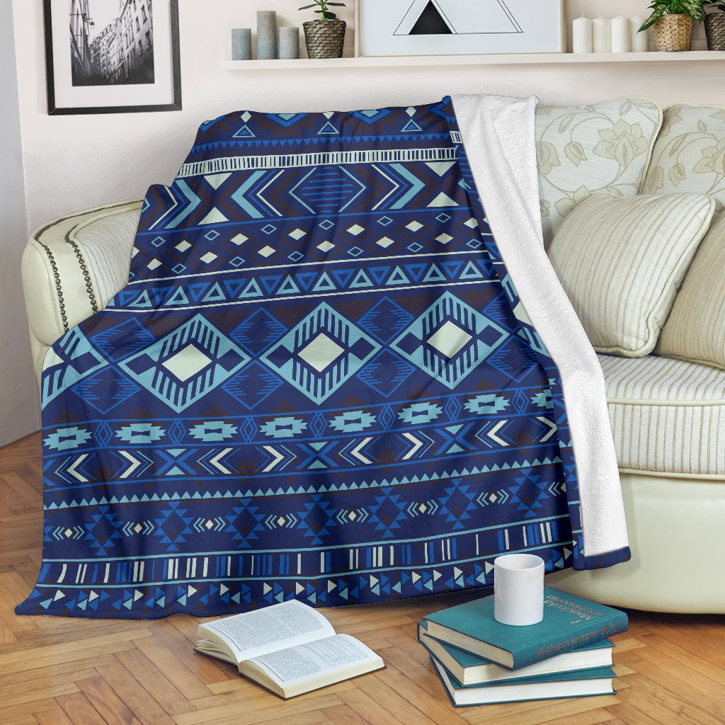 Navy blue geometric pattern blanket draped on sofa, white backing visible