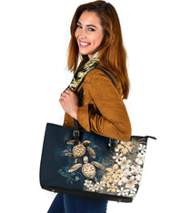 Navy tote with sea turtles and plumeria floral print, top handles with gold buckles