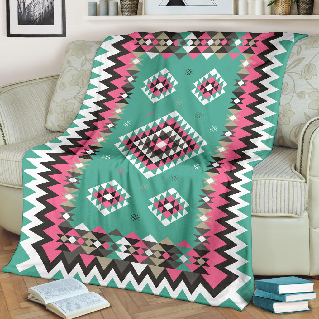 Turquoise geometric blanket with pink, teal, black, and white diamond motifs; chevron edge