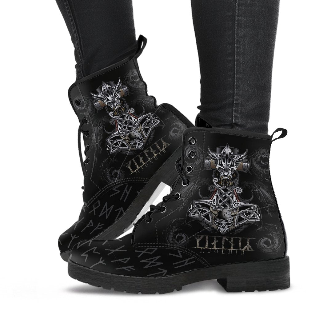 Black lace-up Viking boots on legs, detailed outer artwork and patterned sole