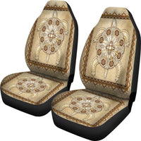 Pair of tan car seat covers with detailed beaded flower cross art and border trim