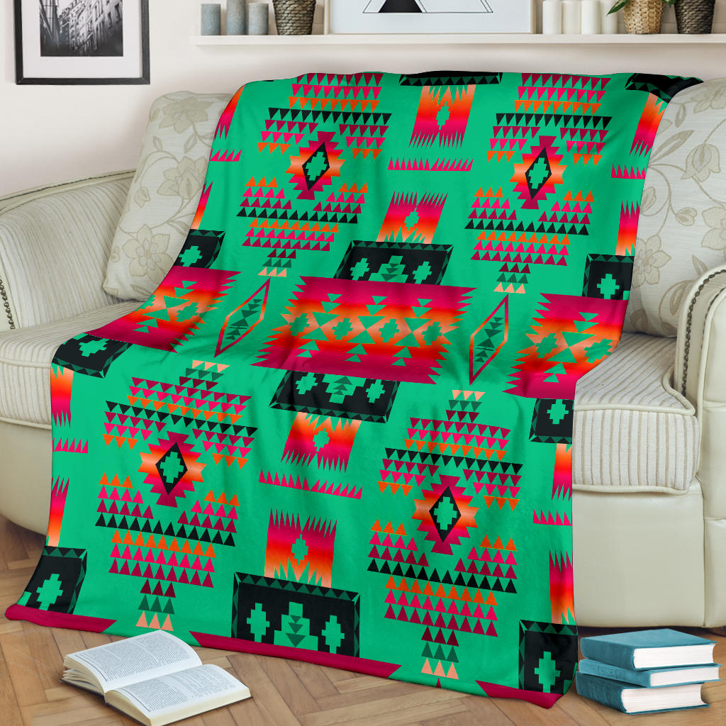 Light green multicolor geometric blanket draped on sofa with red and teal motifs