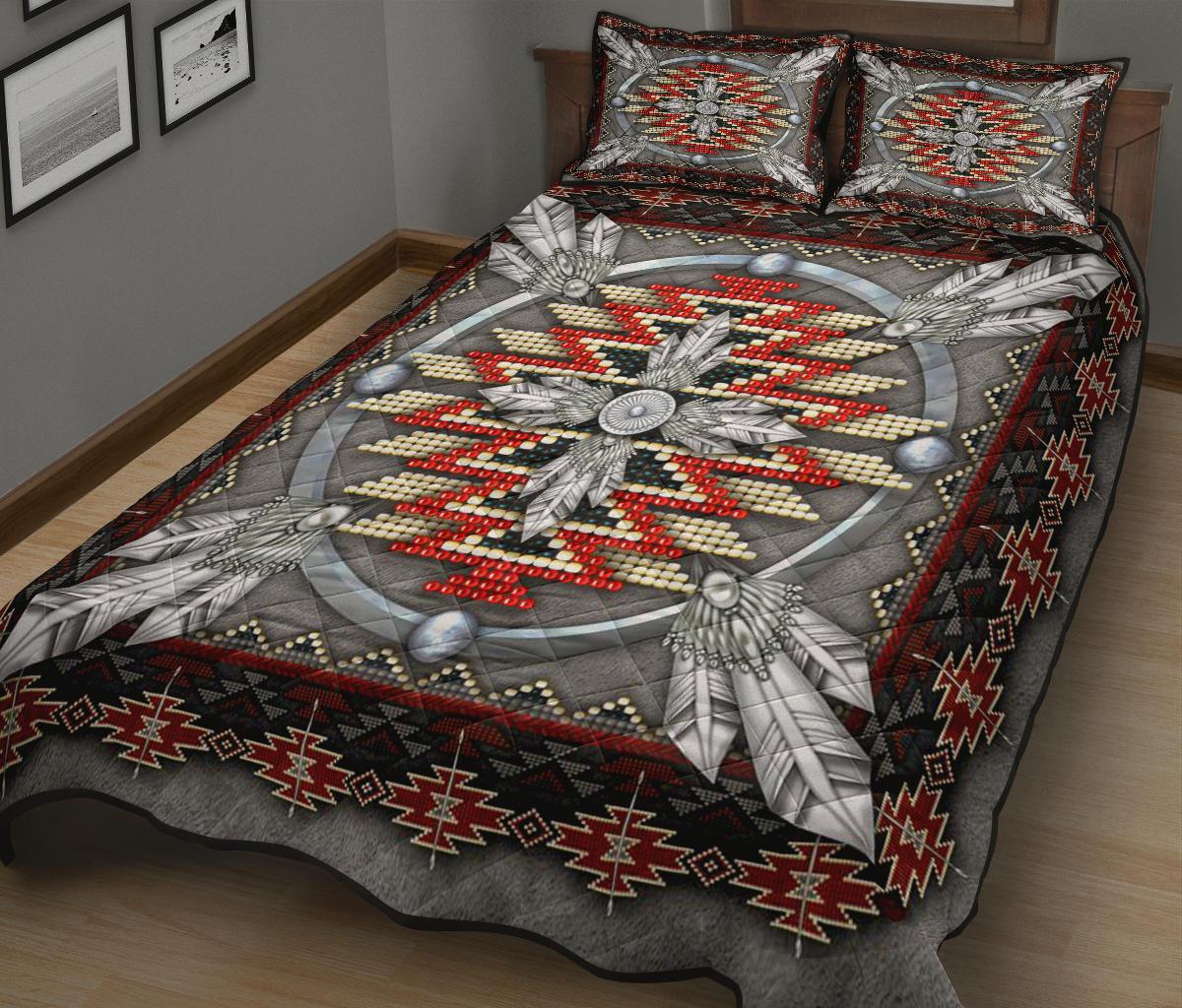 Quilt and matching pillows with gray background, red and cream beaded center, black geometric trim