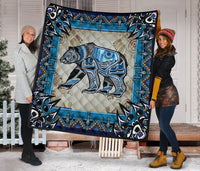 Multicolor quilt featuring a blue-toned bear graphic and Native American-style geometric border