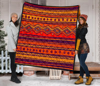 Orange patterned quilt with repeating navy circle outlines and diamond motifs, bordered in dark trim