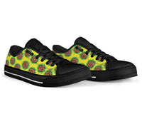 Low-top sneakers with patterned green/yellow Ankara print, black panels, black sole