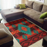 Red geometric patterned area rug featuring teal tree-like shapes and zigzag borders.
