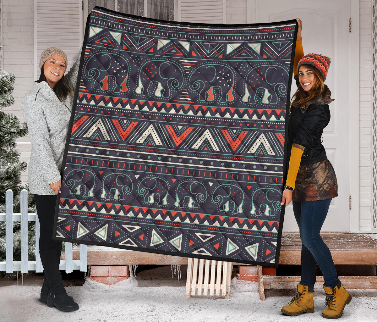 Native quilt spread on porch: dark elephant rows with red, teal, and tan geometric bands.