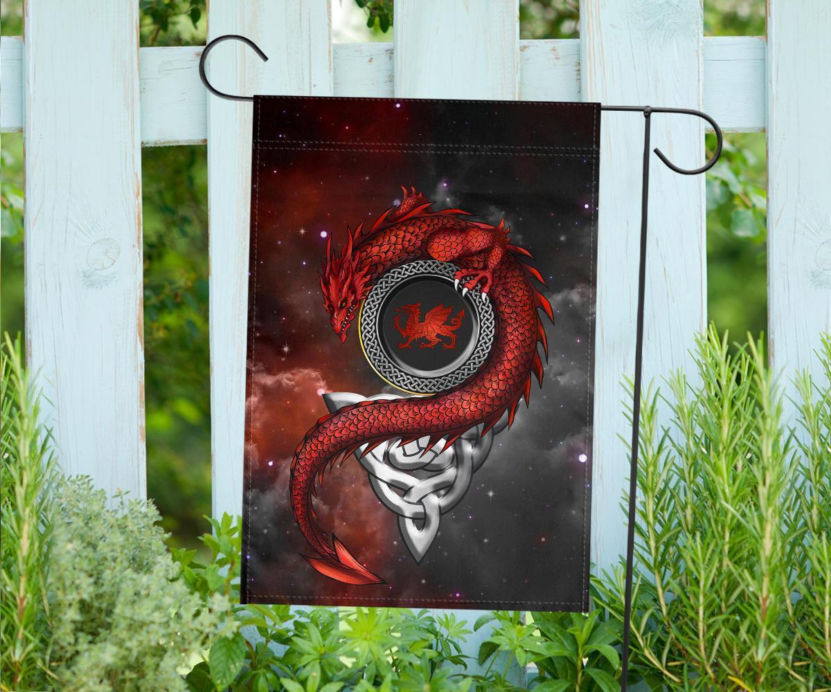 House flag with red dragon and Celtic crest graphic, hanging on fence