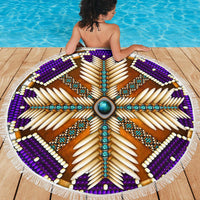Round beach blanket laid out: purple mandala with turquoise center and white fringe trim