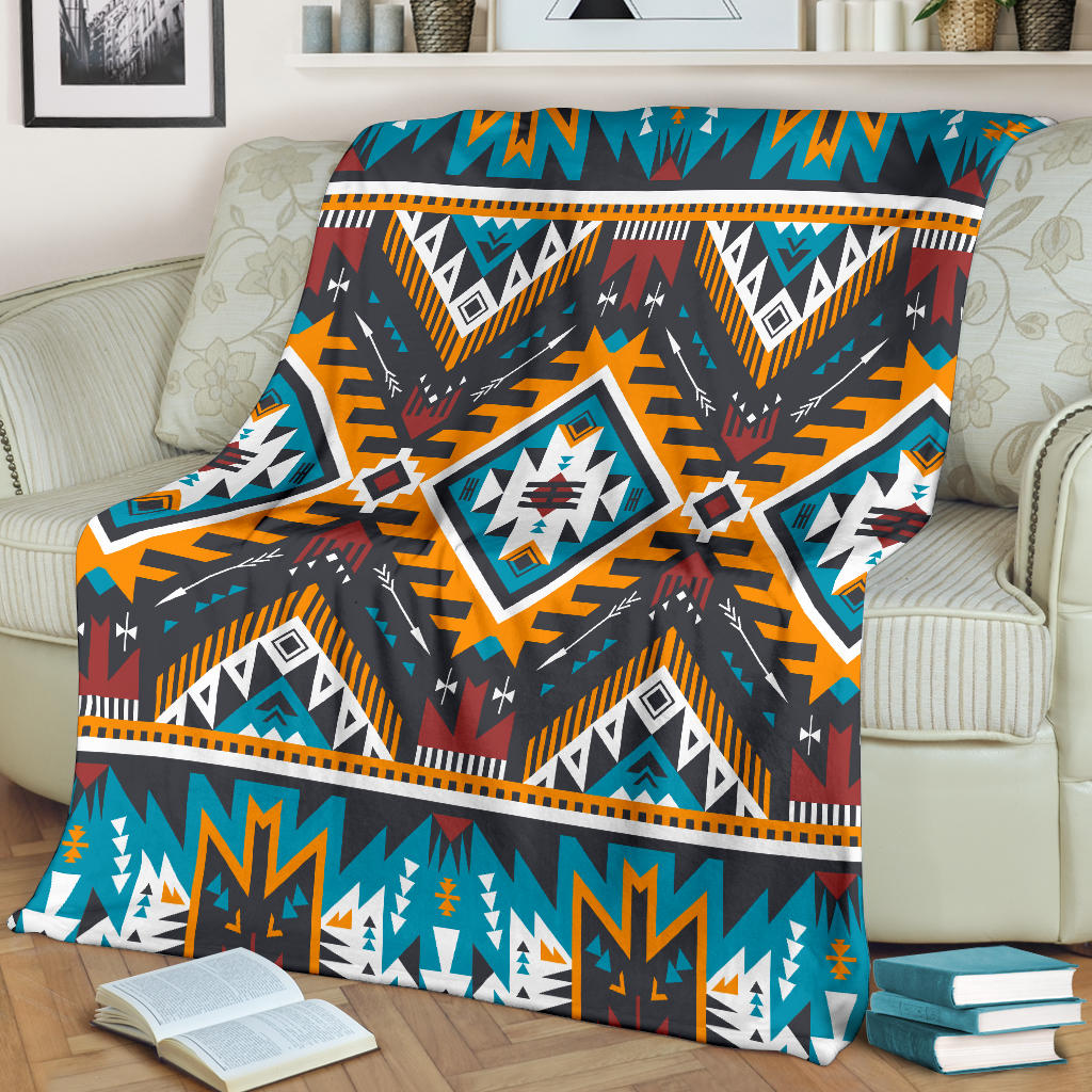 Aztec-style geometric blanket spread out, navy base with teal, orange, red, and white accents