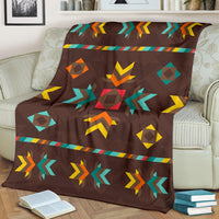 Brown blanket with multicolor geometric pattern, draped over a sofa arm