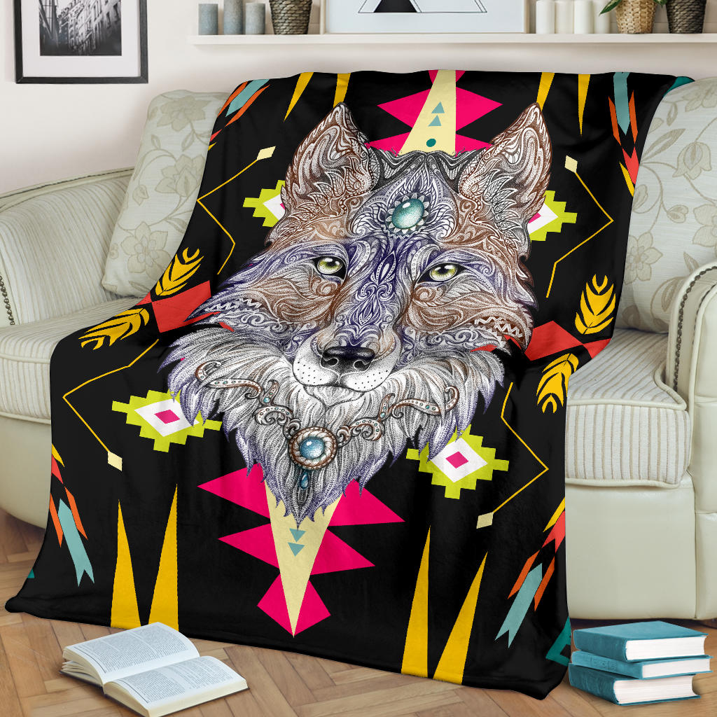 Stylized wolf face blanket draped on couch, black base with bright geometric shapes