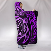 Purple hooded blanket draped open, neon-lilac tribal turtle design across center