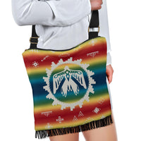 Colorful Native-style crossbody bag with fringe hem and adjustable black strap, worn look