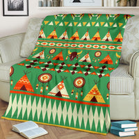 Green blanket showing tents, bison, and dreamcatcher motifs with diamond row stripe