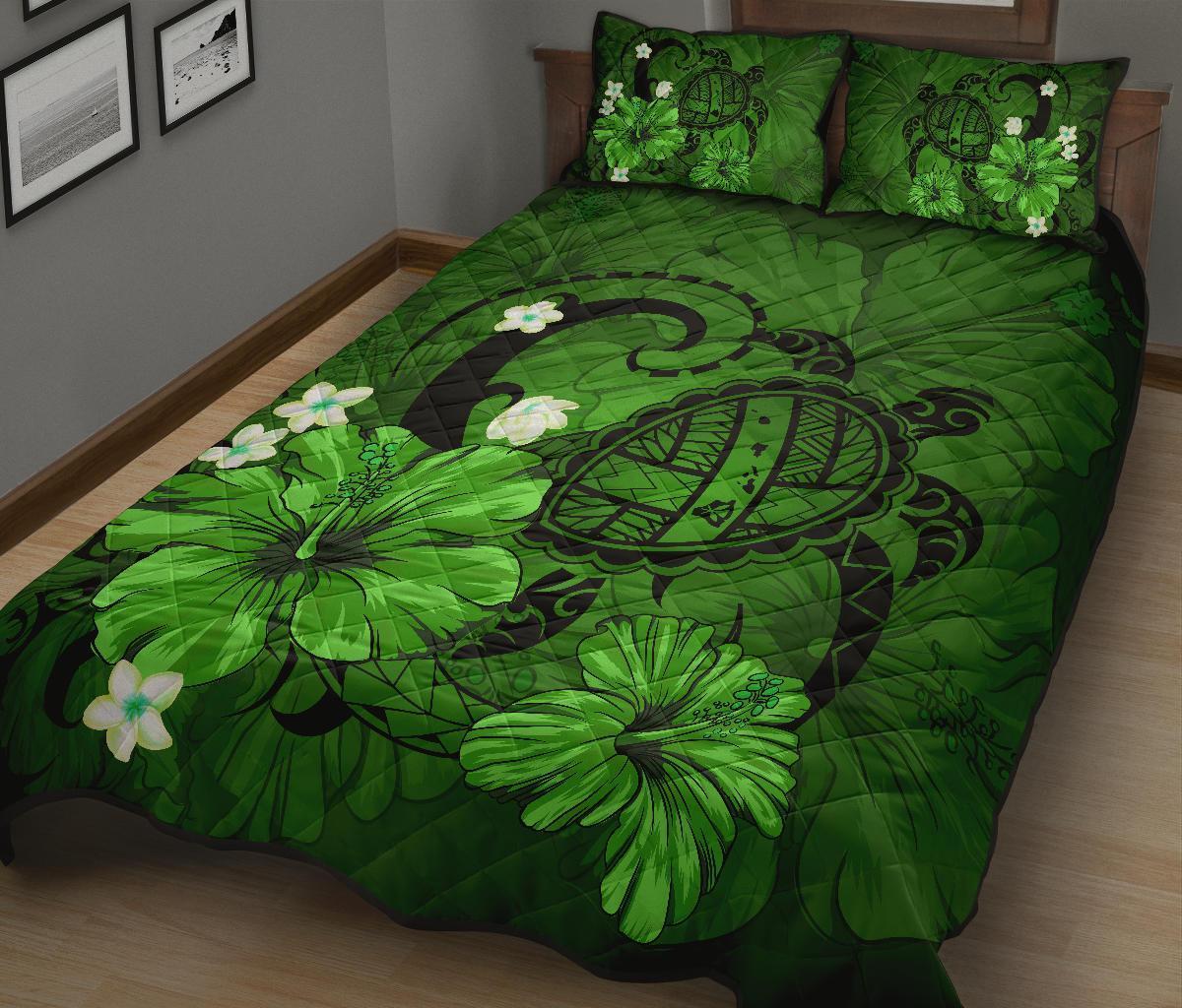 Green quilt set on bed with turtle shell circle, leafy flowers, and two matching pillows