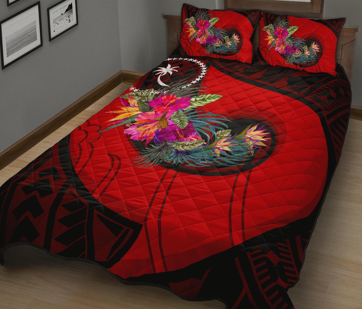 Red quilt with bold floral Polynesian hook pattern and two matching red pillows