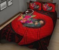 Red quilt with bold floral Polynesian hook pattern and two matching red pillows