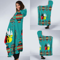 Turquoise hooded blanket cape with oversized bear paw graphic and multicolor motifs