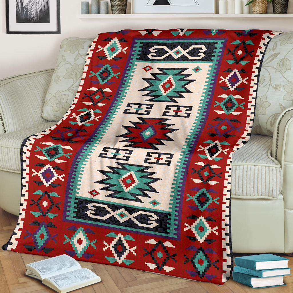 Red, cream, and teal geometric blanket draped over sofa with bordered trim