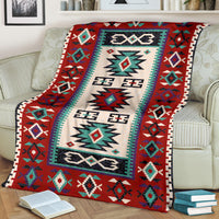 Red, cream, and teal geometric blanket draped over sofa with bordered trim