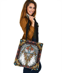 Multicolor tote bag with black handles, open-frame tribal pattern and feathered centerpiece