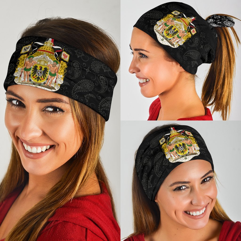 Black paisley bandana-style face covering with coat-of-arms graphic, angled view