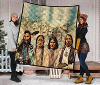 Quilt featuring a group of Native American faces with feather details, diamond-pattern stitching