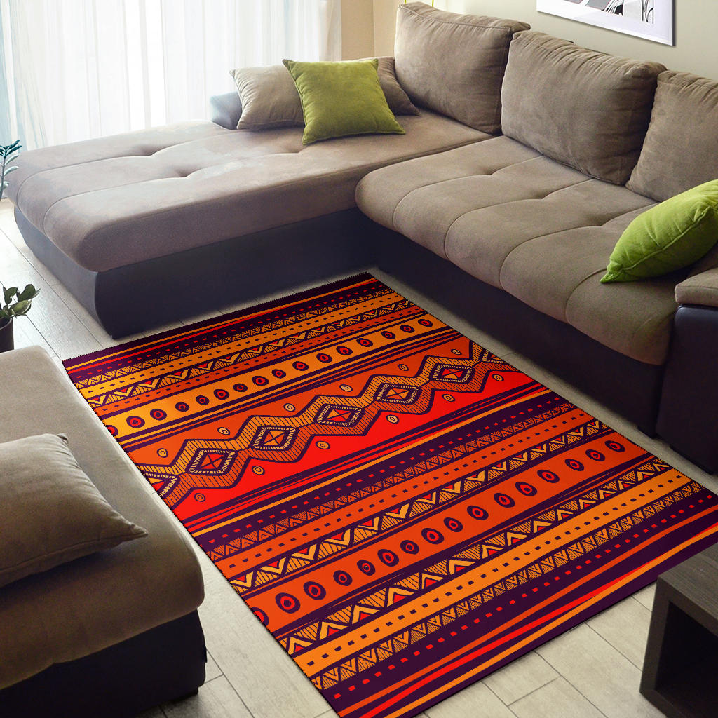 Orange tribal-style area rug with bold stripe bands and repeating circle and diamond shapes.
