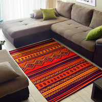 Orange tribal-style area rug with bold stripe bands and repeating circle and diamond shapes.