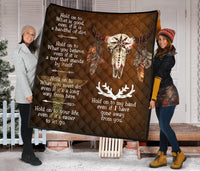 Brown quilt featuring centered bison skull, dreamcatcher-style feathers, and white text