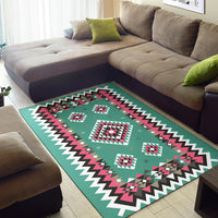 Teal geometric area rug with pink and black diamonds, plus zigzag white border