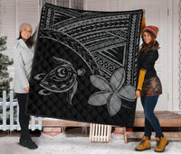 Black quilt held up: grey turtle illustration and plumeria flower over quilted diamond stitching