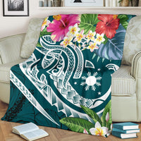 Turquoise floral blanket with hibiscus blossoms, plumeria cluster, and white geometric/tribal motifs
