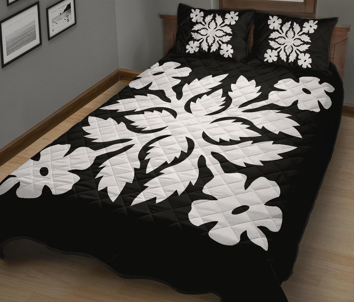 Quilt bed set with bold black background and white floral motifs across the comforter