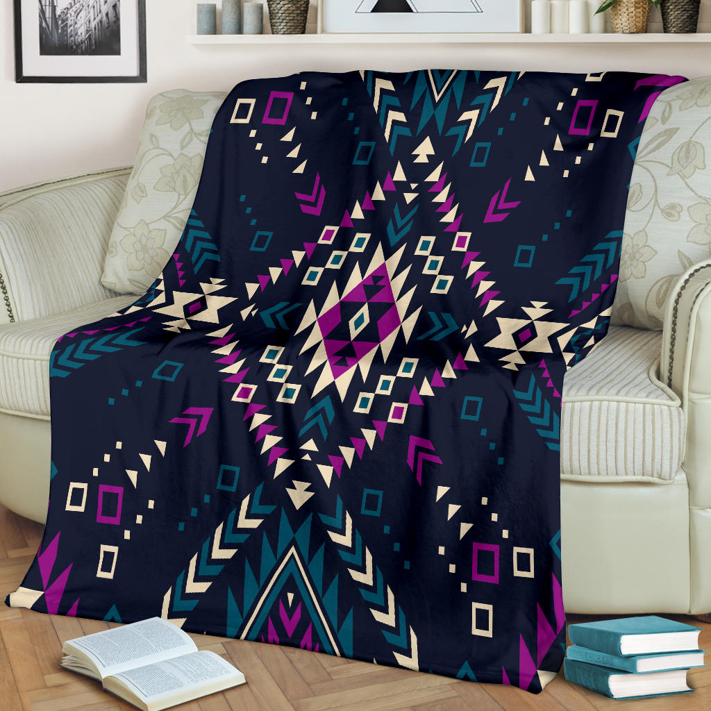 Dark tribal patterned blanket spread on couch; multicolor geometric shapes