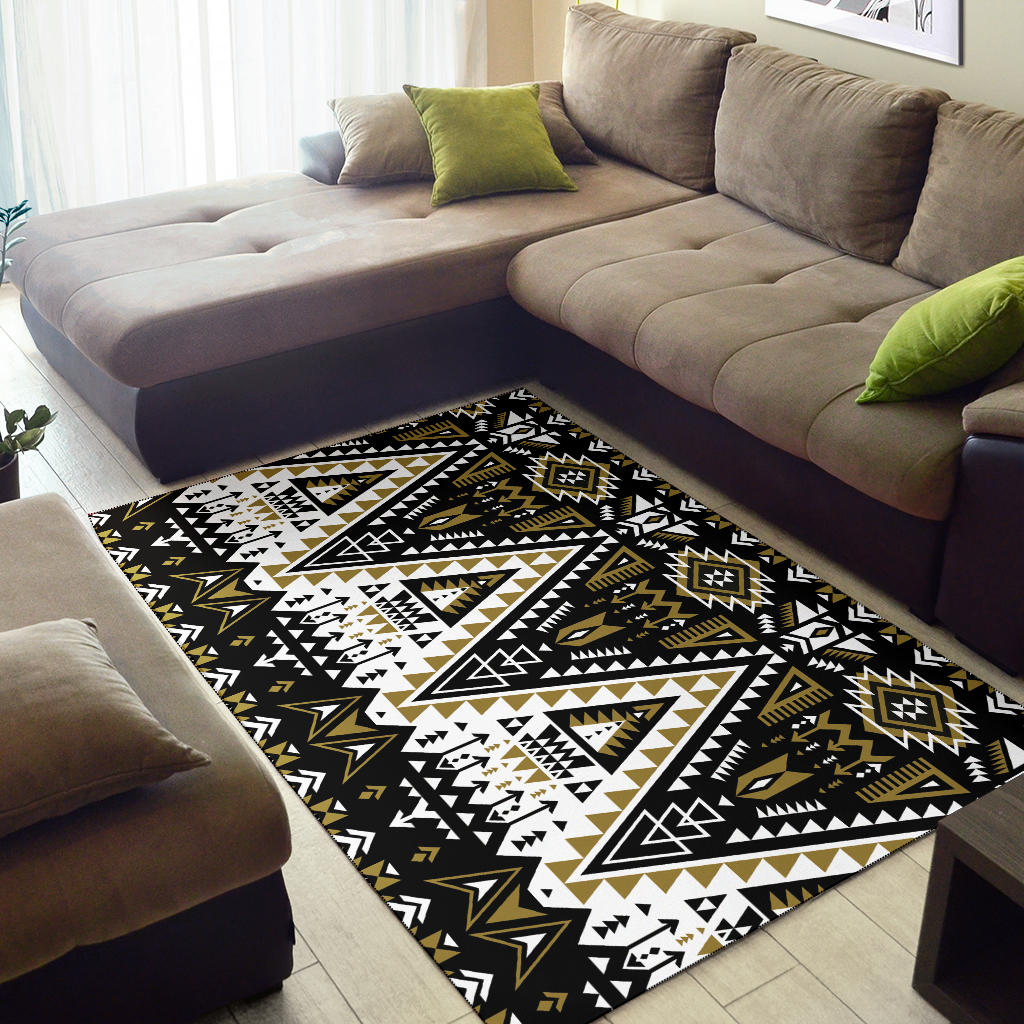 Geometric tribal area rug on floor, black base with white and gold arrow and medallion