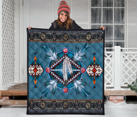 Blue quilt with dreamcatcher medallion, feather details, and multicolor geometric side panels.
