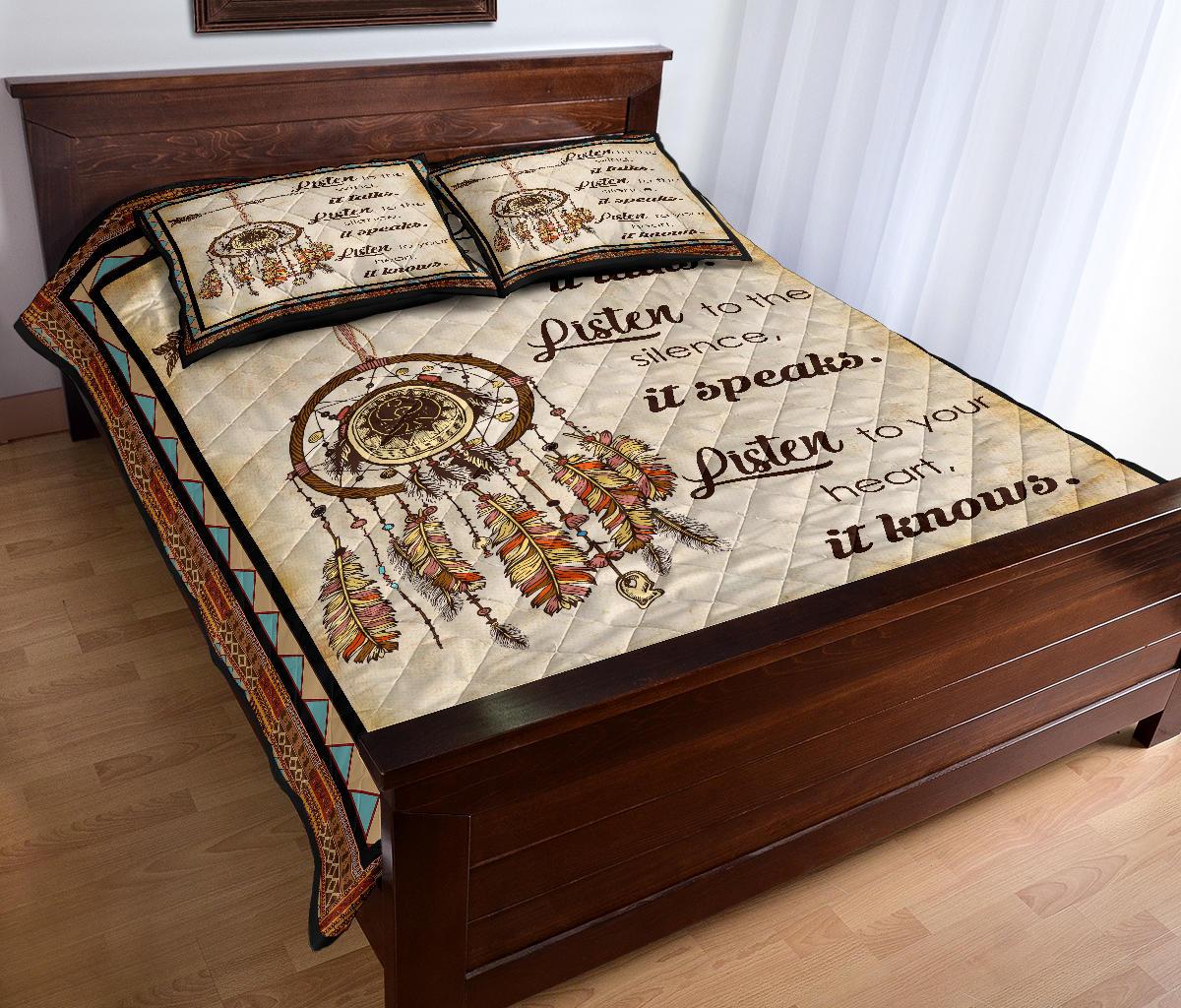 Quilt bed set on bed with dreamcatcher and feather motifs plus two matching pillows