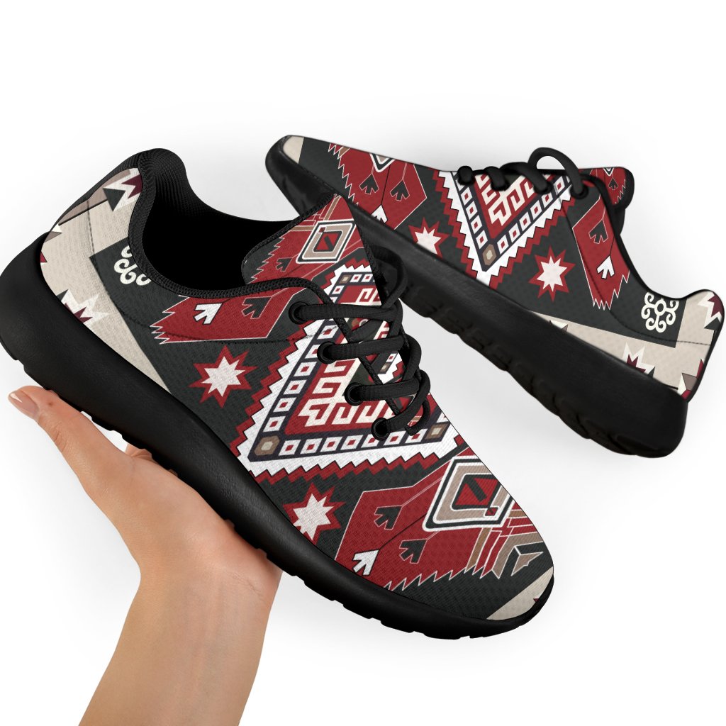 Sport sneakers on feet, red-brown tribal design with white accents, black laces